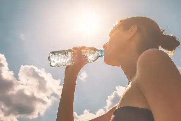 Hydration: The Secret Ingredient for a Toned Stomach and Enhanced Fitness 3 Image of woman drinking water to hydrate Farnham after run.